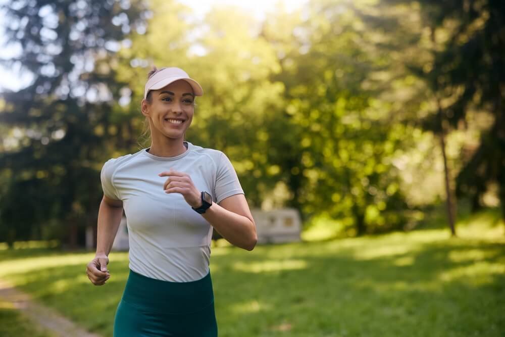 a woman jogging in the woods with a pleasant look on her face