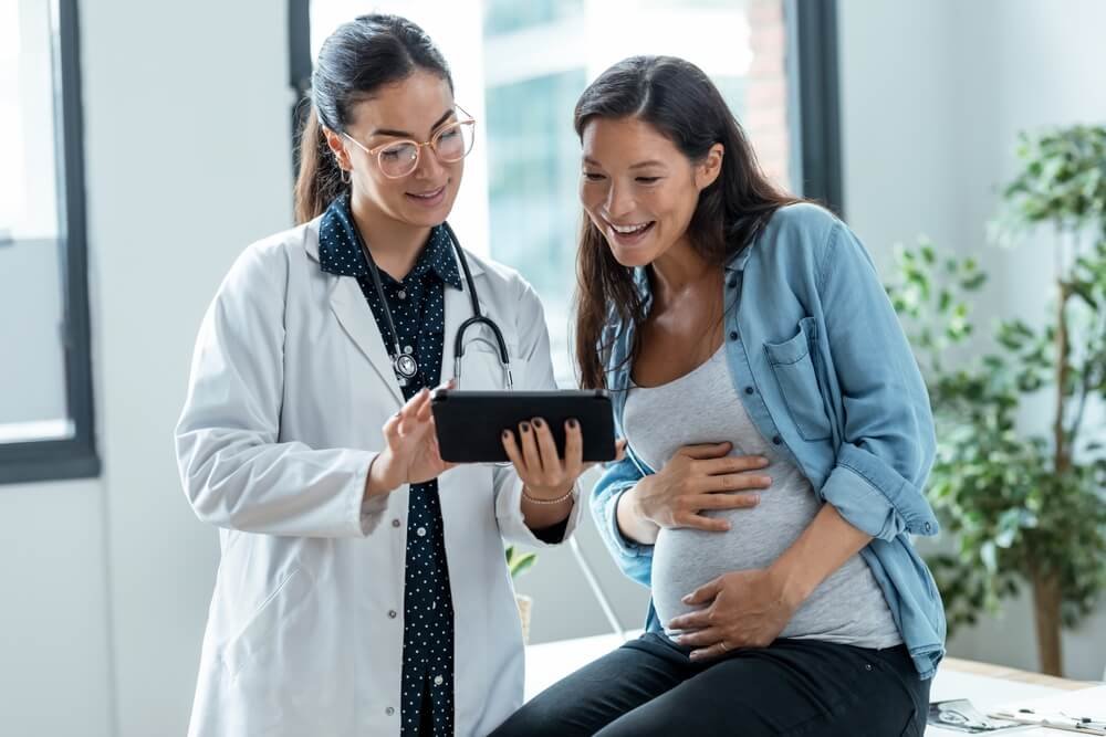 A picture of a pregnant woman talking to a doctor