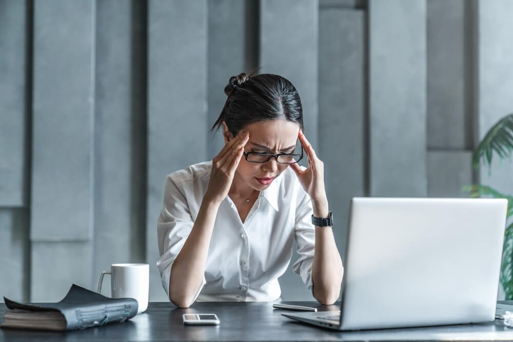 a woman grimacing with a headache